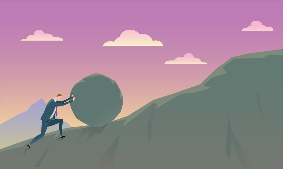 A businessman rolling a stone up a hill, representing sisyphean tasks.